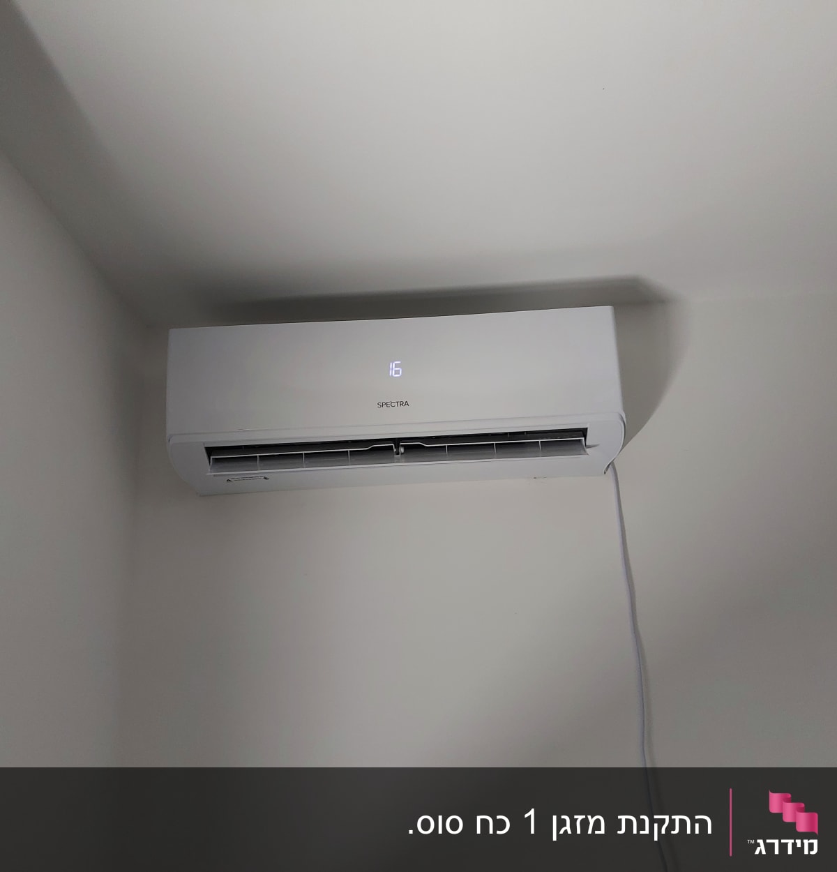 מזגן קיר לבן מותקן על קיר עם תצוגה דיגיטלית